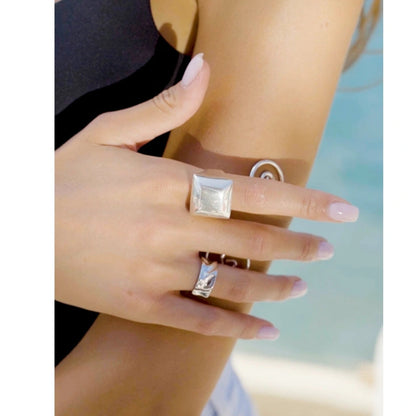 Close-up of a person's hand wearing two rings with a blurred background